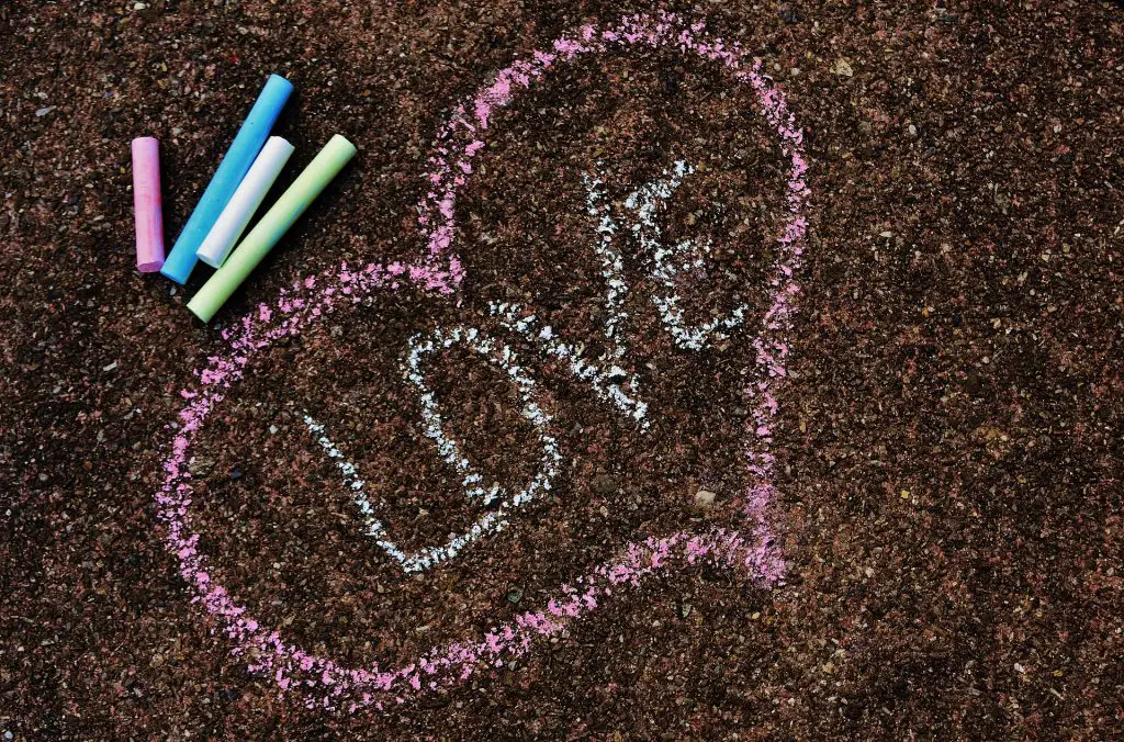 Das Wort "Love" und ein Herz wird als lustige Aufgabe für den Junggesellinnenabschied auf die Straße gemalt
