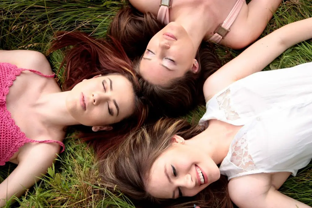 Frauen bei einer Bridal Shower liegen zusammen im Gras