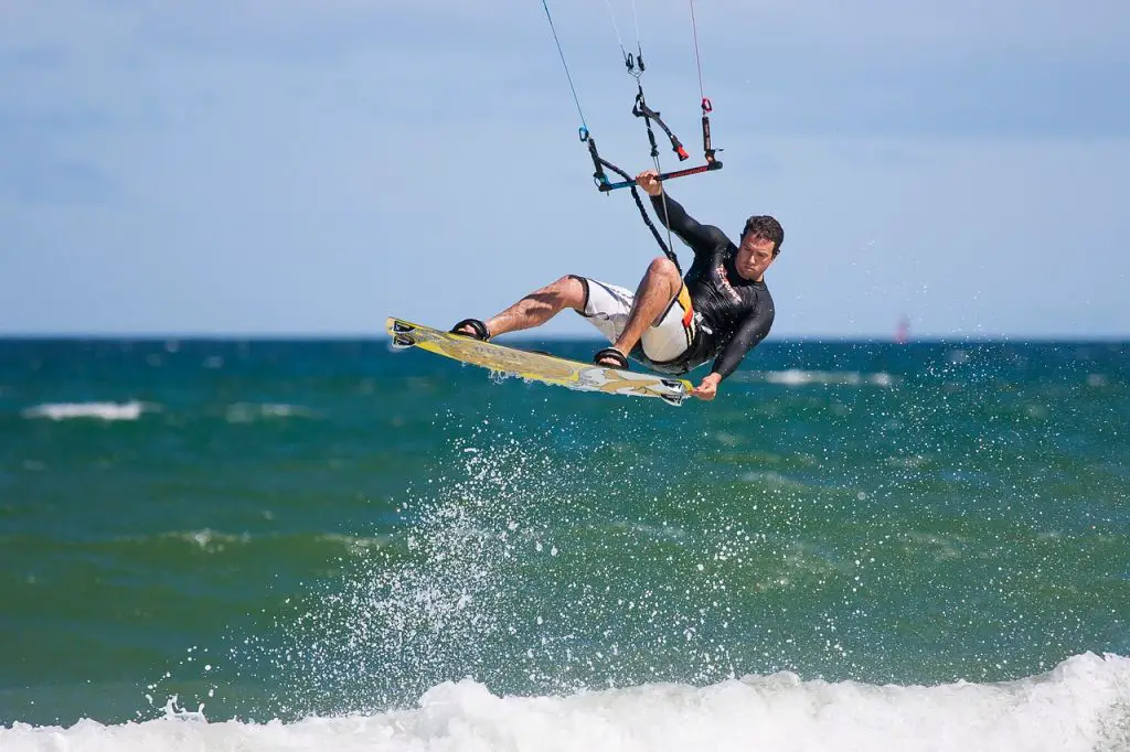 Mann macht wilde Tricks beim Kitesurfen