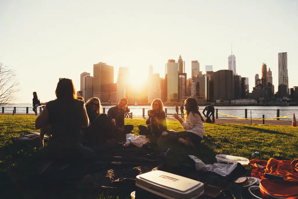 Friends having picnic in front of city panorama for low budget bachelor party