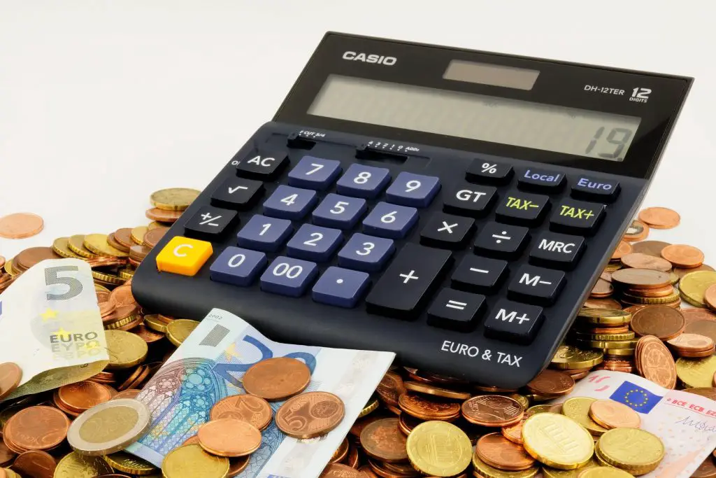 Calculator on a pile of money - financial chaos as a polterabend mistake