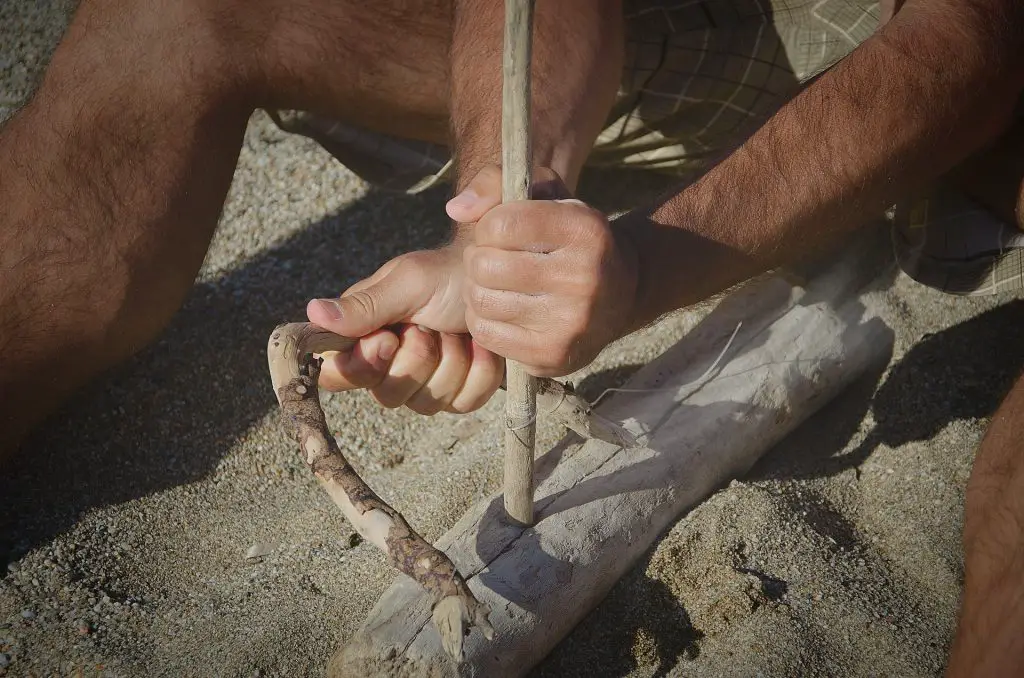 Man makes fire with twigs at survival day