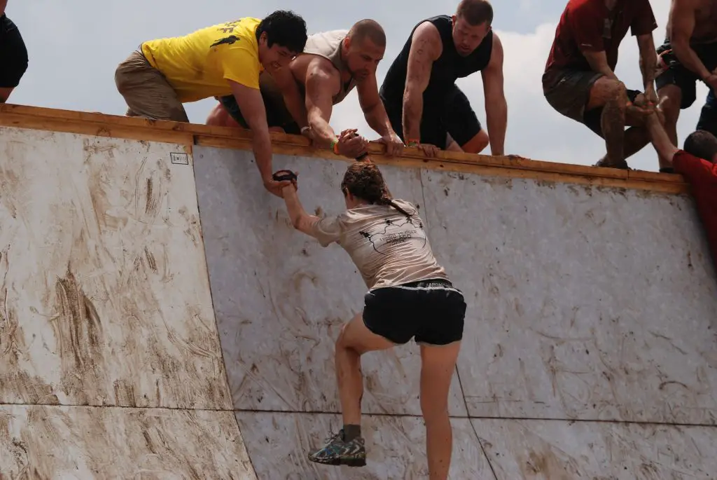 Mann hilft Frau eine Rampe hinauf beim Wildsau Dirt Run