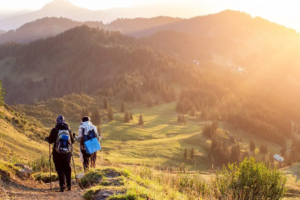 Two people hiking in front of mountain panorama