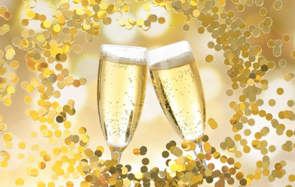 two champagne glasses collide surrounded by golden confetti - stag night with a difference