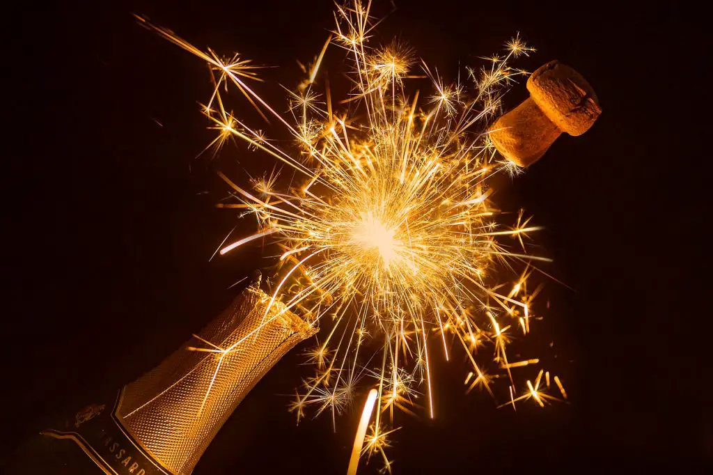 Champagnerkorken ploppt in Feuerwerk von der Flasche zum Luxus Polterabend